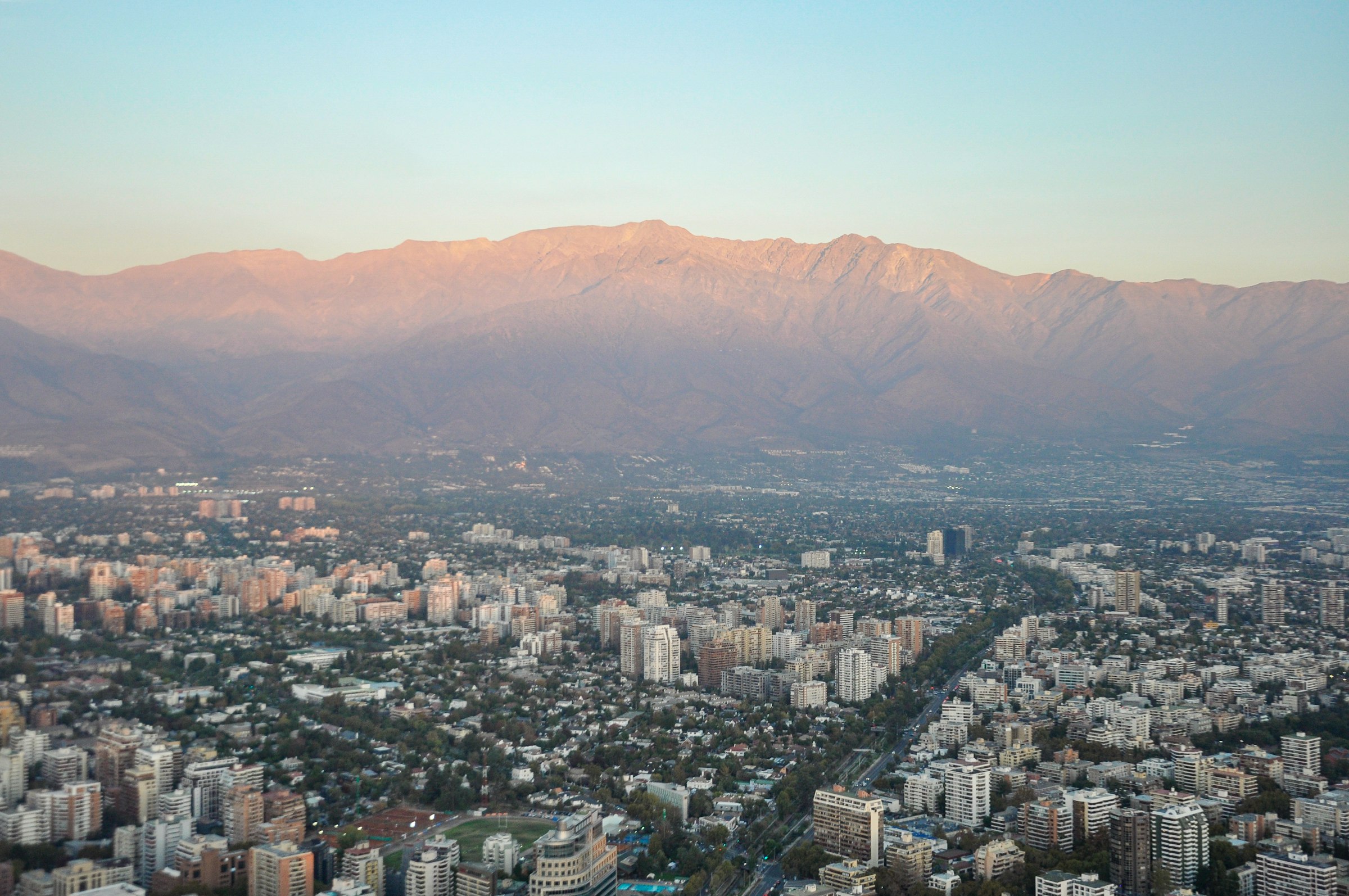 Vista aérea de Santiago al atardecer, con la cordillera de los Andes al fondo.